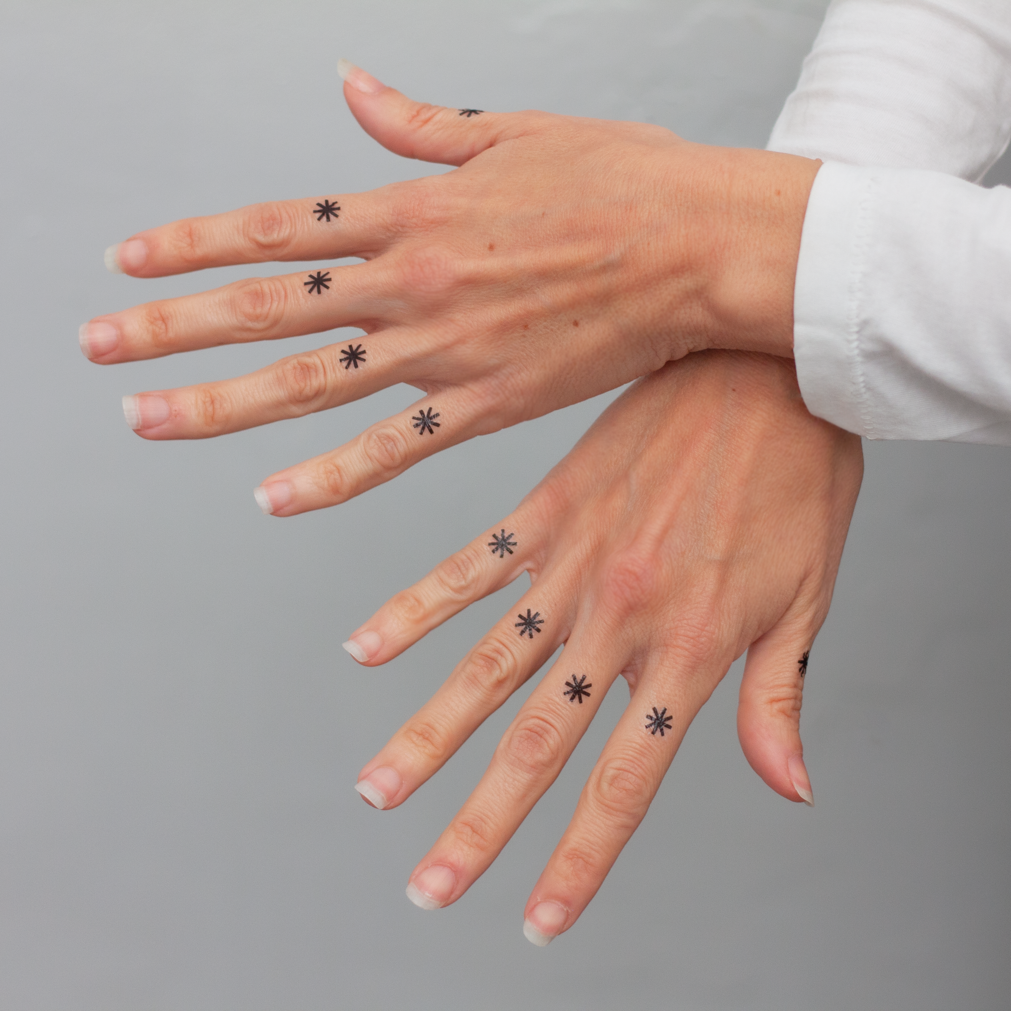 tatuaje asterisco dedos