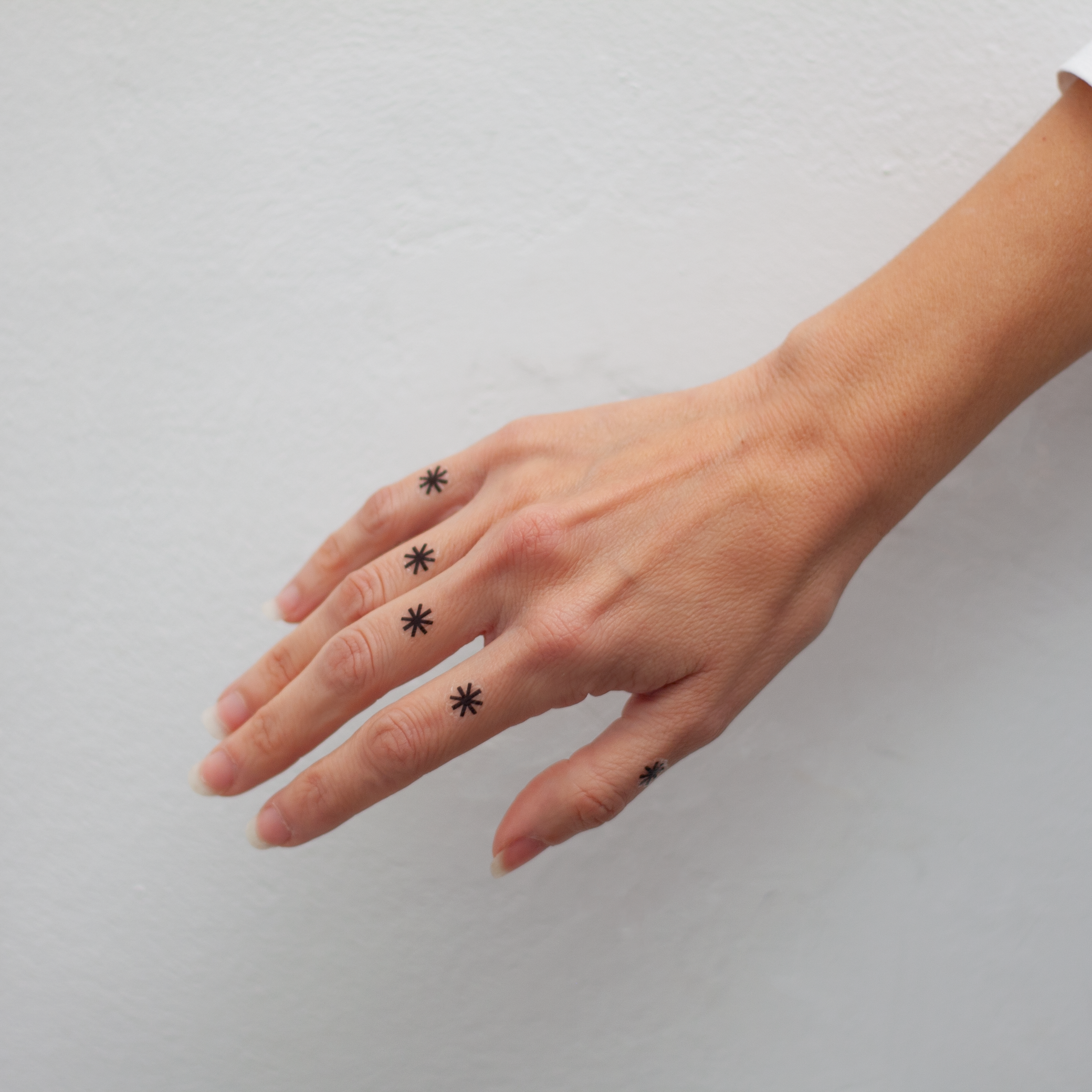 tatuaje asterisco dedos