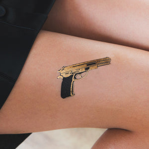 tatuaje pistola dorada