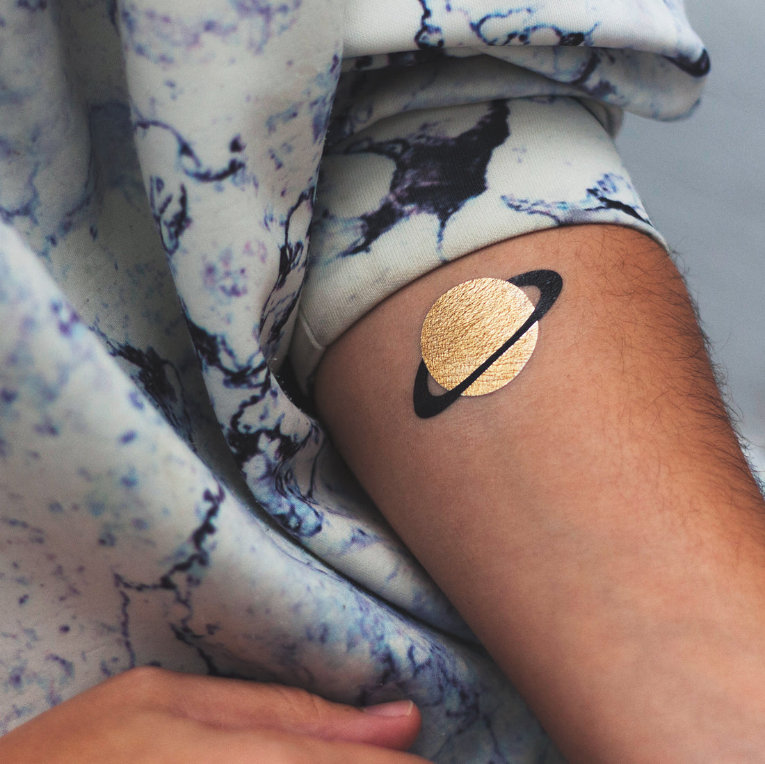 tatuaje planeta dorado