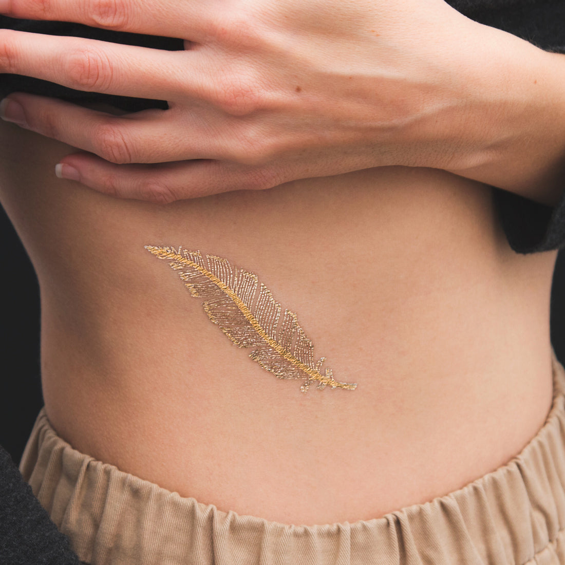 tatuaje pluma dorada